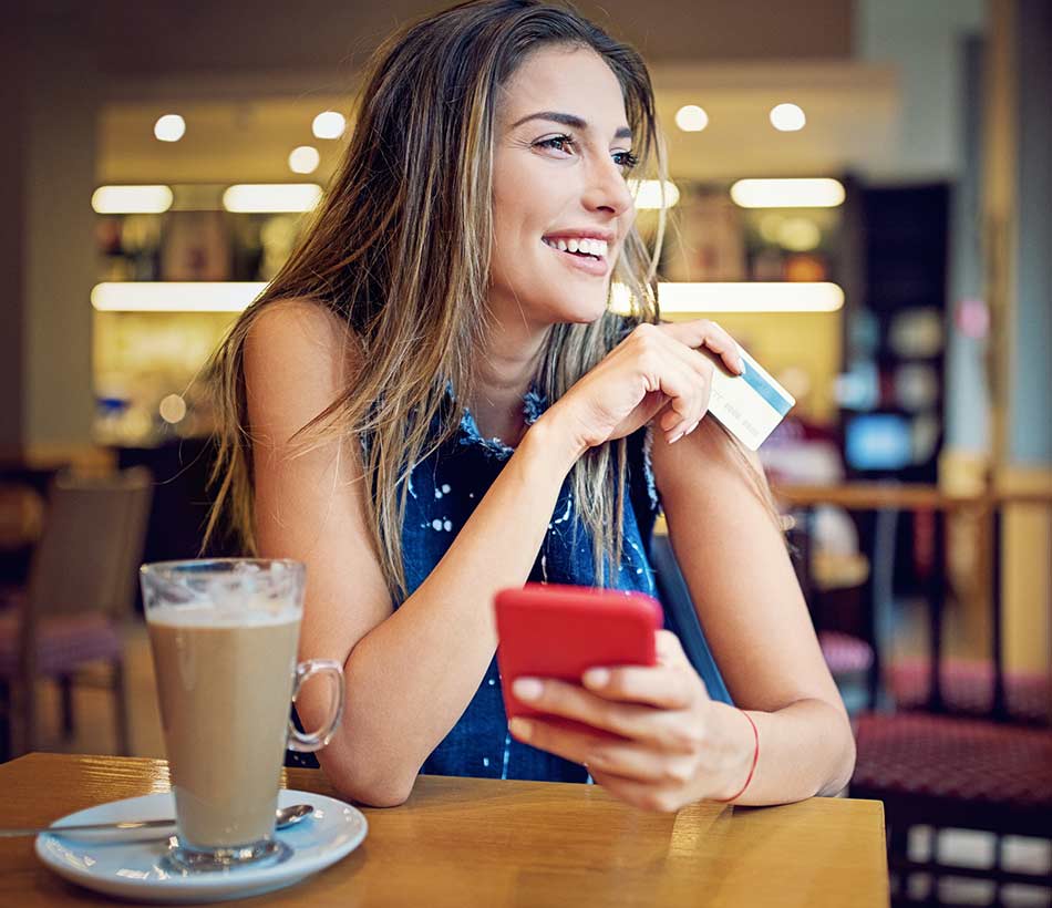 Person paying for her coffee with her check card.